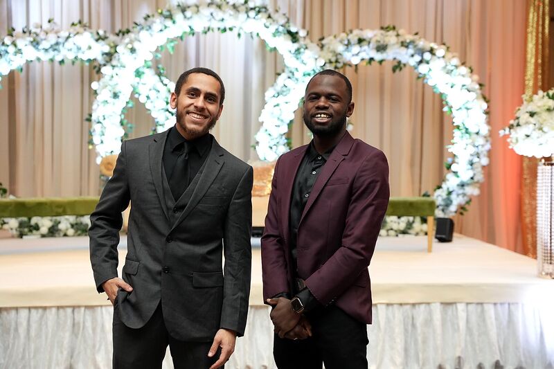 Two Sonar Audio Visual founders standing in front of a floral arch
