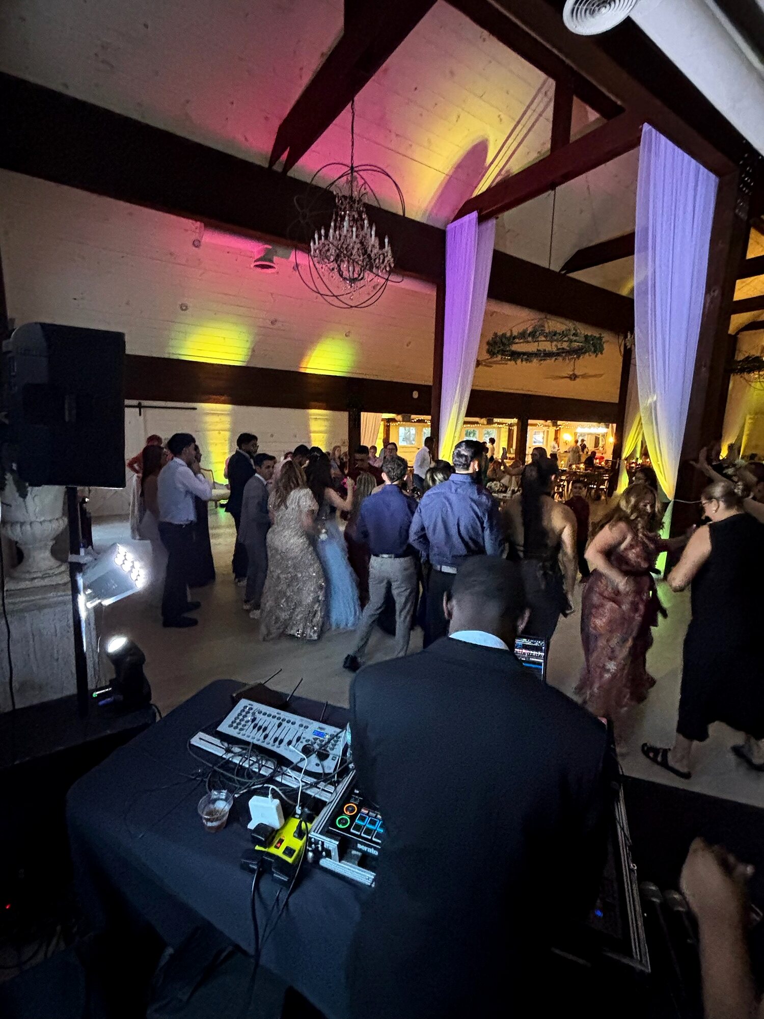 A packed wedding dance floor seen from behind the Sonar Audio Visual booth