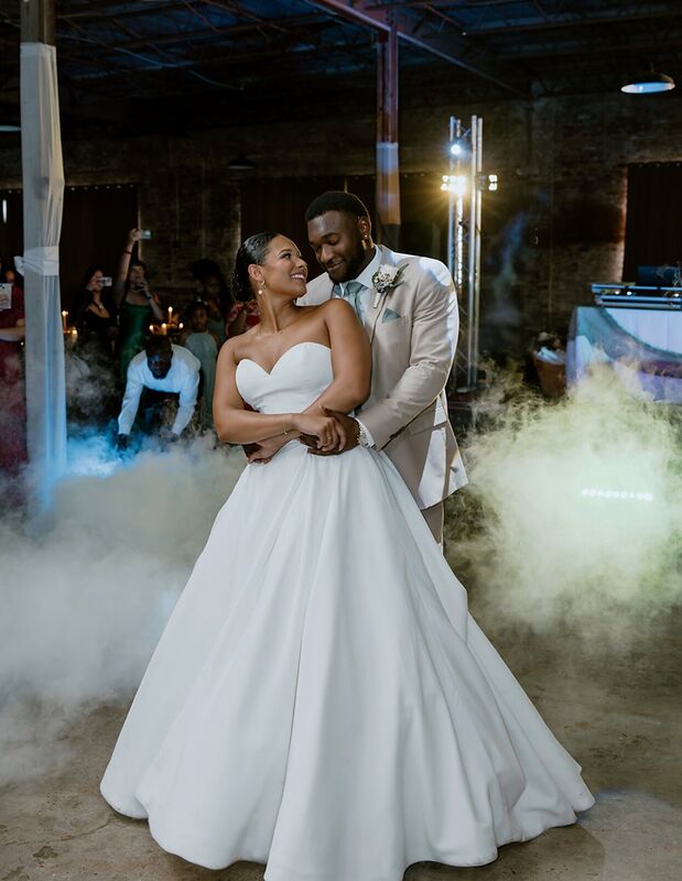 A couple dancing inside a low cloud of fog during their first dance