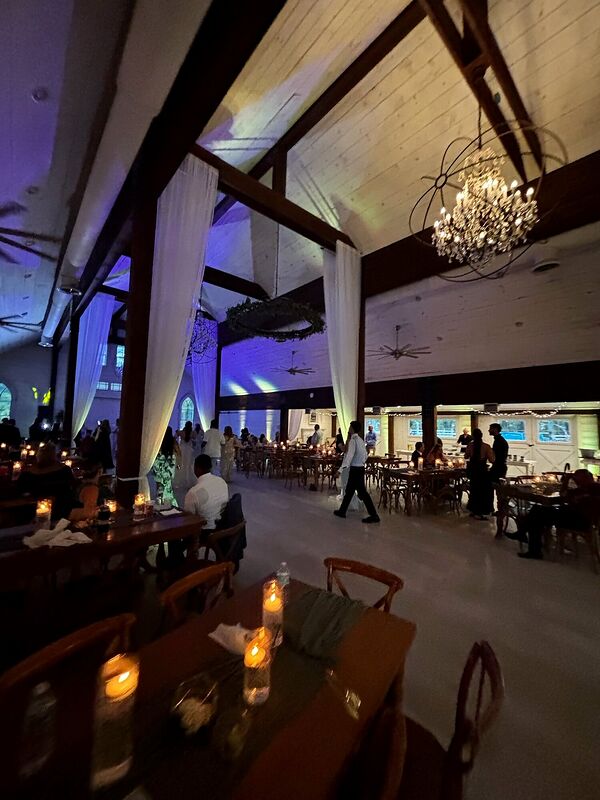 Reception tables lit with candles under a beamed ceiling